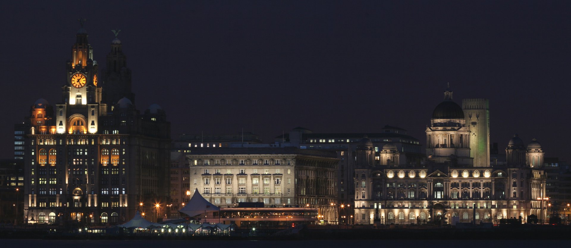 Liverpool’s illuminated Pier Head and waterfront reflected in the River Mersey